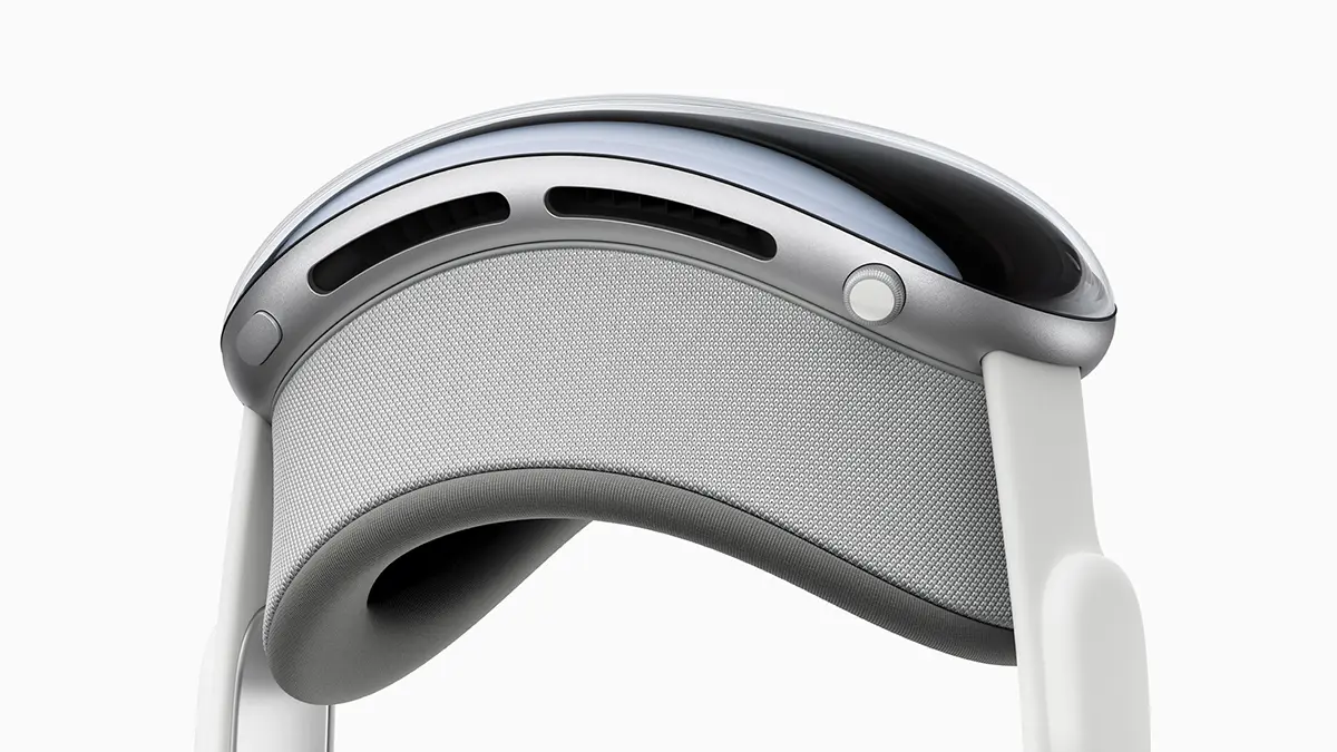 Close-up of a person wearing the Apple Vision Pro headset, their eyes visible through the front display as they interact with a floating 3D architectural model.