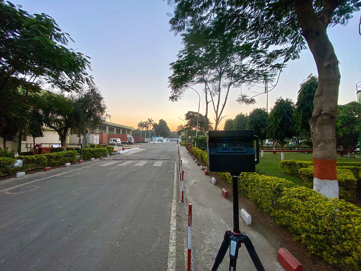 Matterport Pro2 camera on a tripod at the tree-lined exterior entrance road of the Gwalior facility.