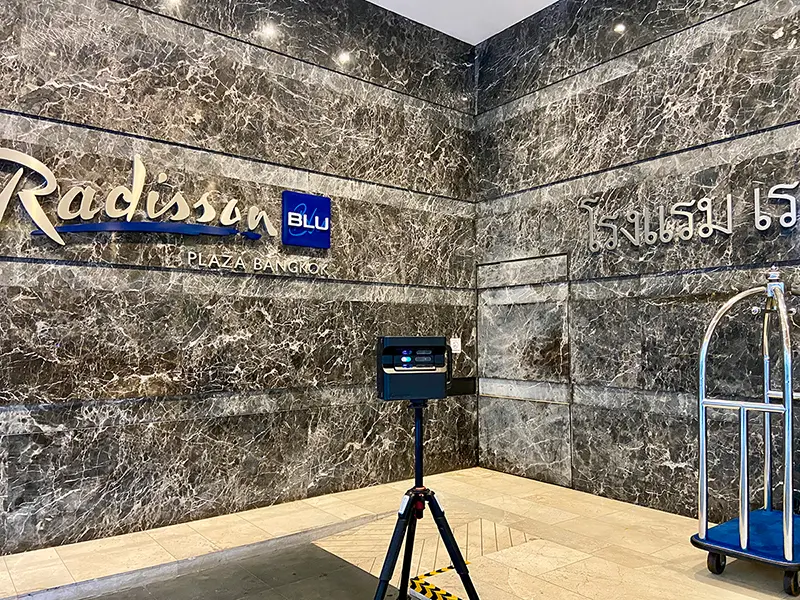 A professional Matterport Pro2 camera on a tripod in a large, modern building.