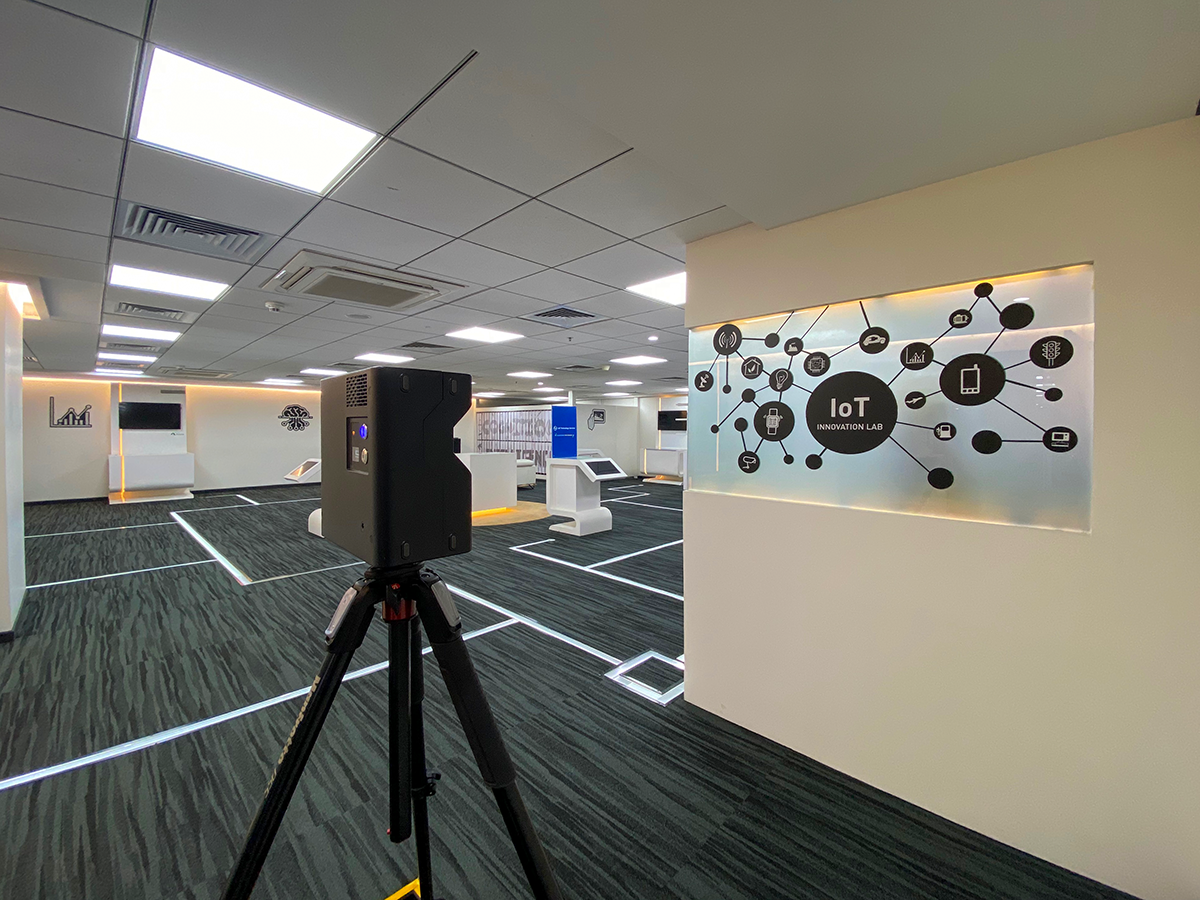 Team members collaborating remotely on a construction project using a digital twin on a screen.
