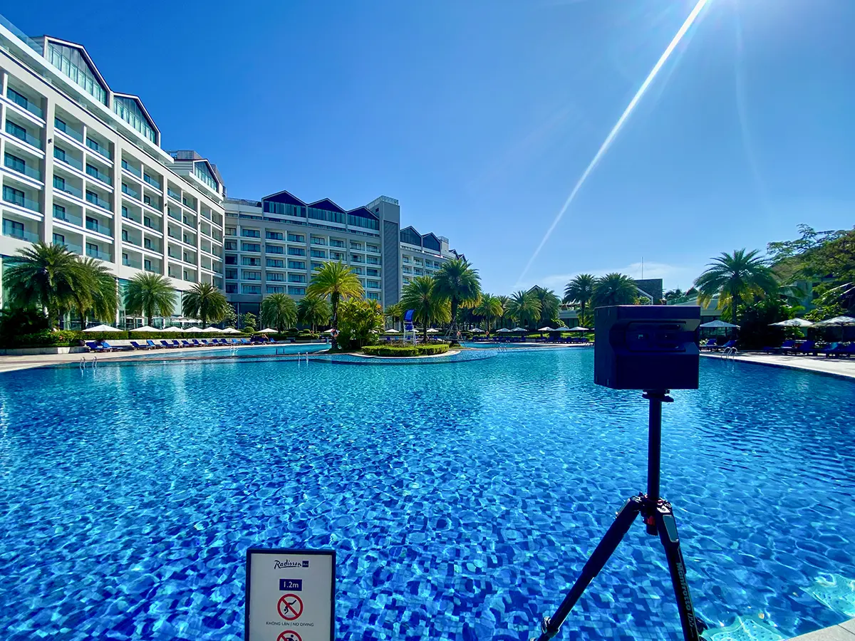 A stunning beachfront resort with pool and lounge chairs, captured for a virtual tour.